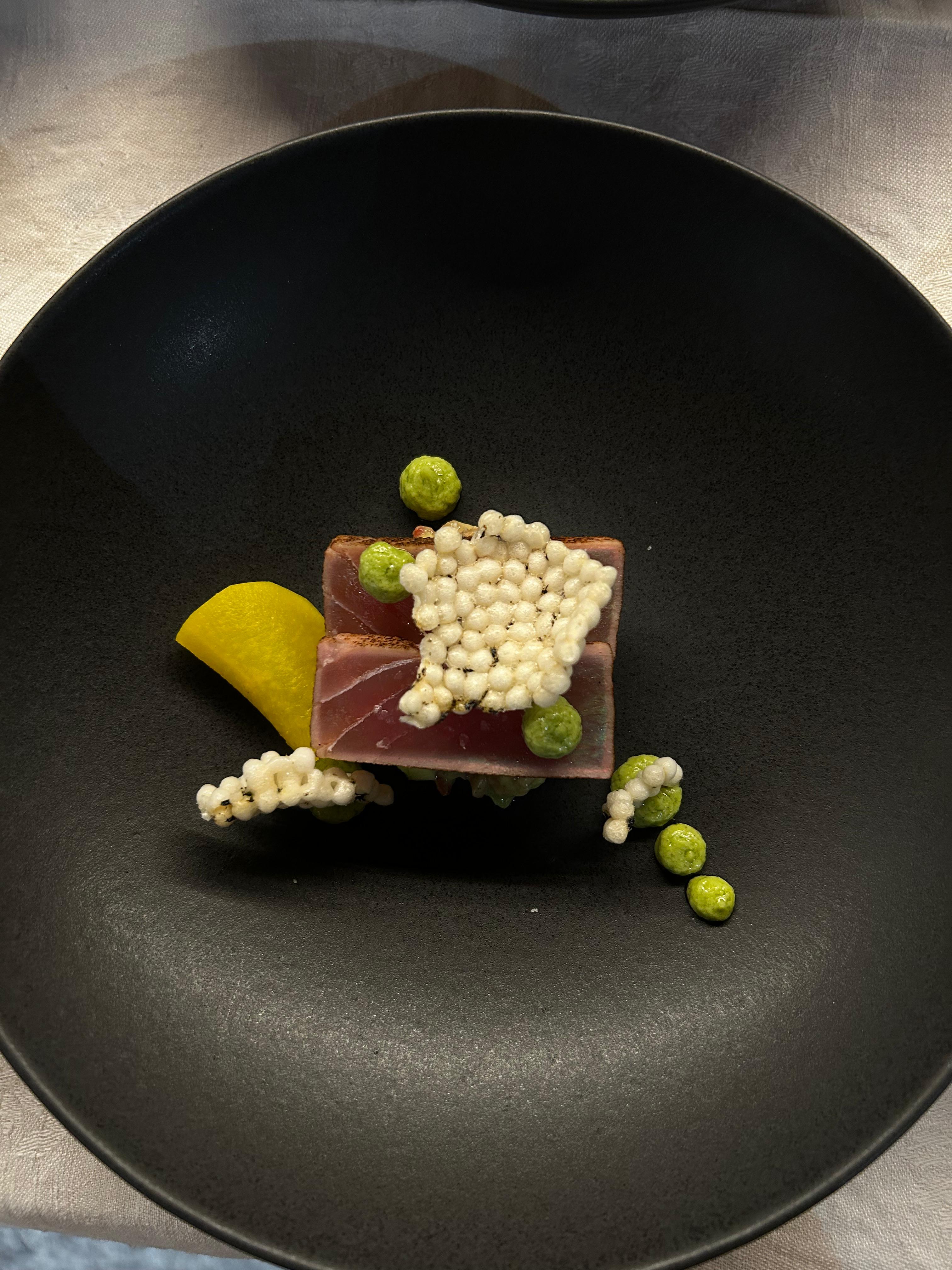 Vorspeise: Thunfisch-Tatar auf Erbsen-Püree mit gepufftem Reis und Zitronen-Filet auf dunkler Schale