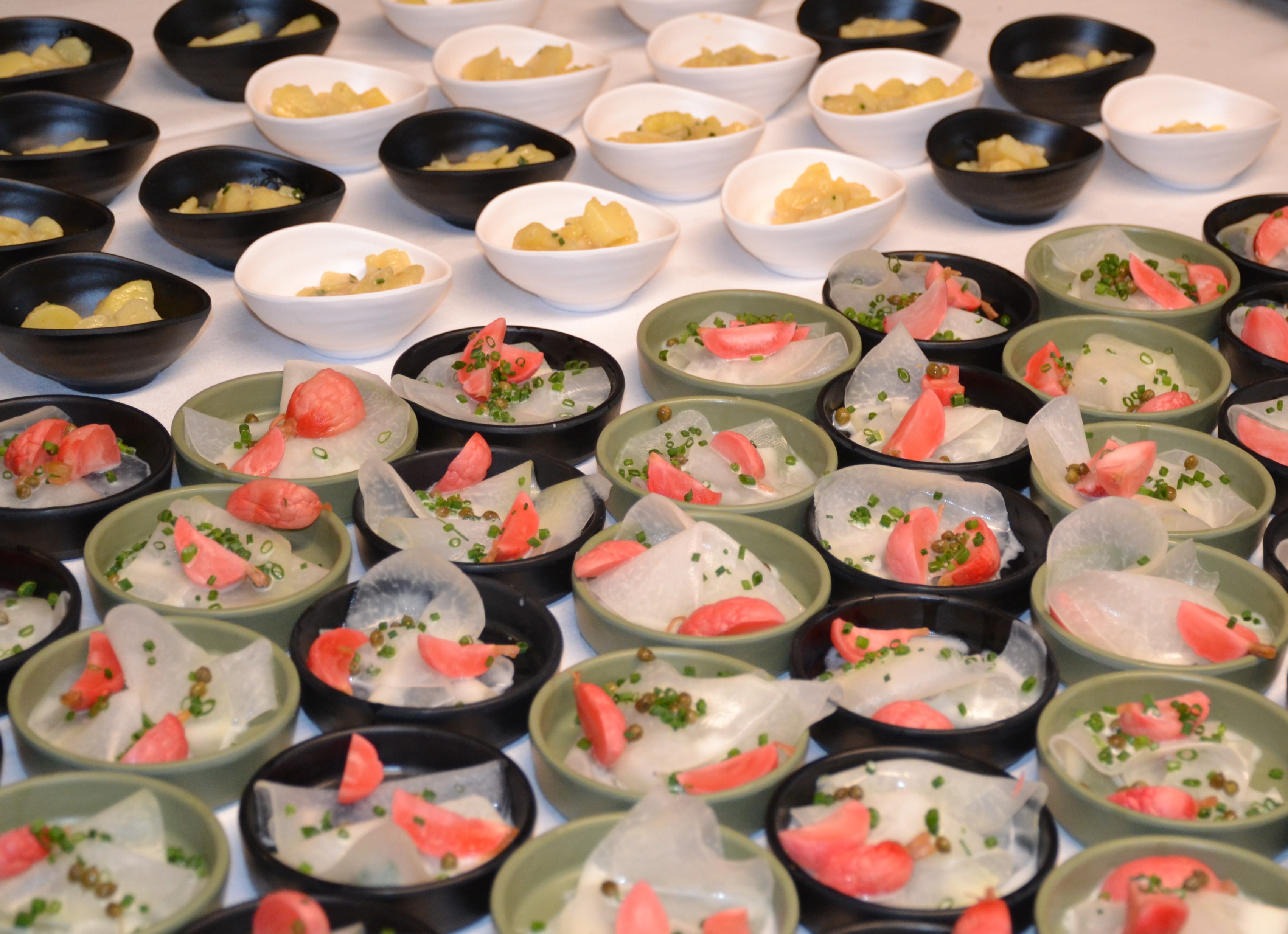 Aufgereihte Apéritif-Schälchen mit Tatar, Carpaccio und Pickles am Empfangsbuffet