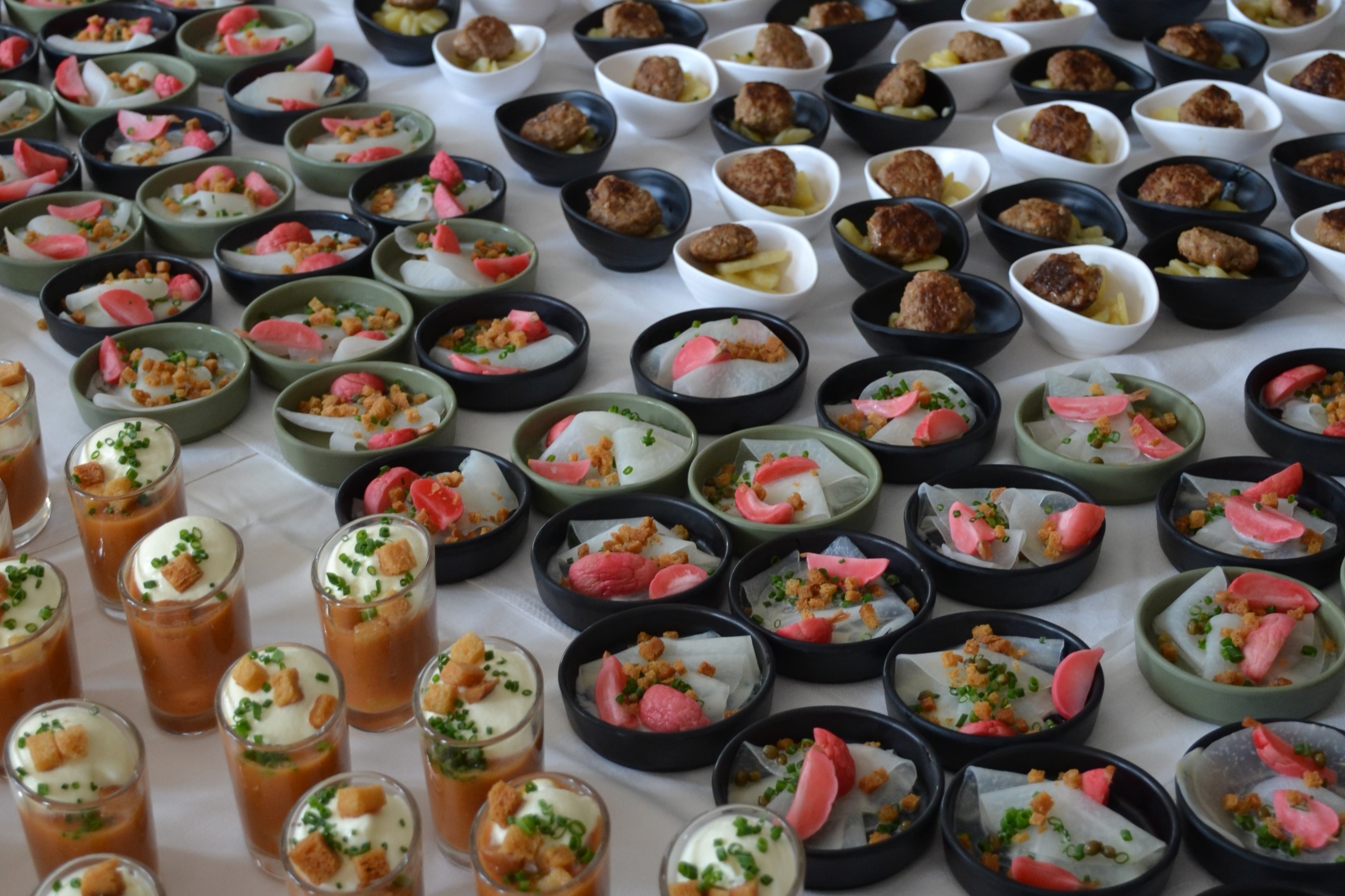 Großes Apéritif-Buffet mit Klops, Kohlrabi-Carpaccio und Suppen-Shots in mehreren Reihen