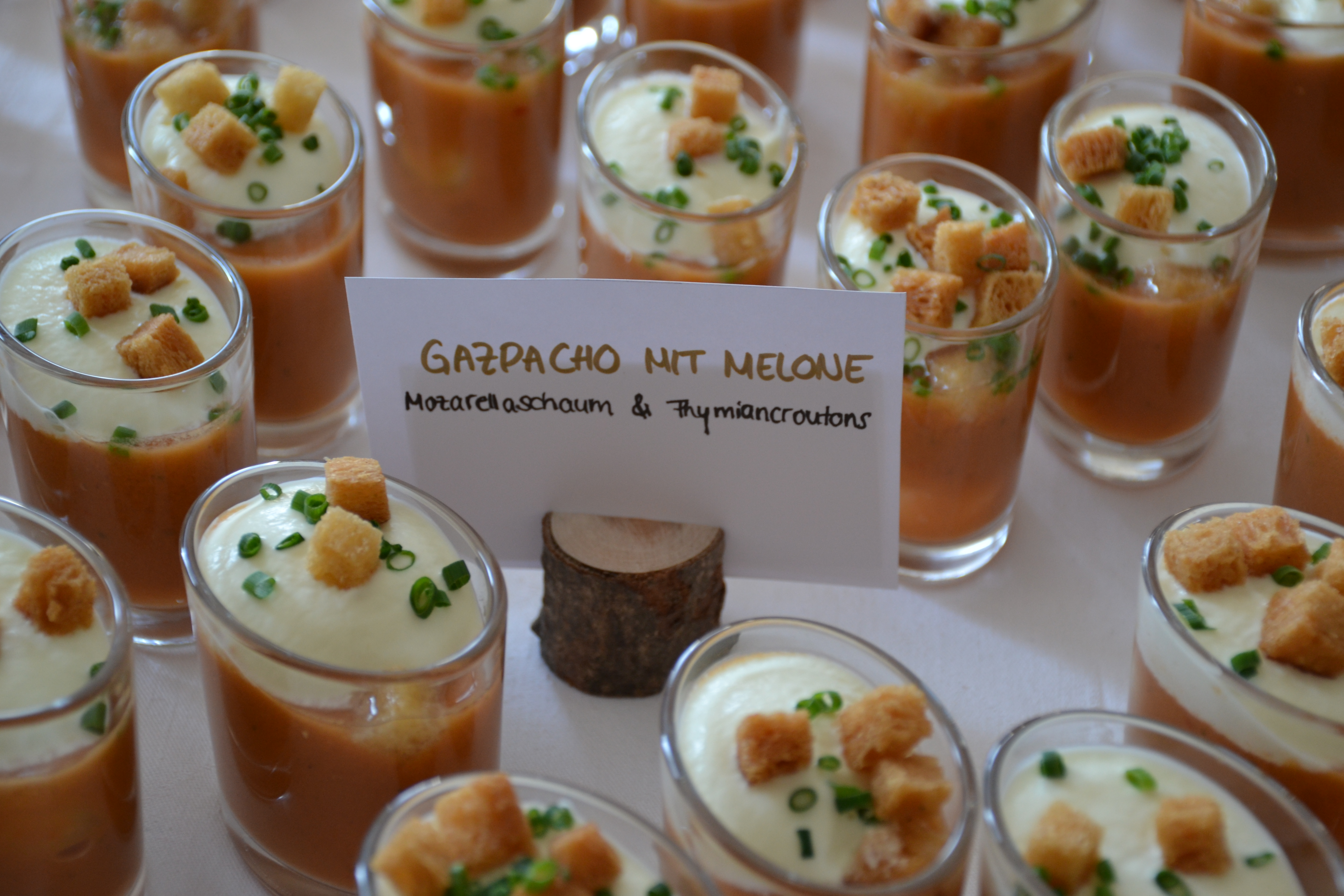 Gazpacho mit Mozzarella-Schaum und Thymian-Croûtons, Beschriftungskarte im Vordergrund