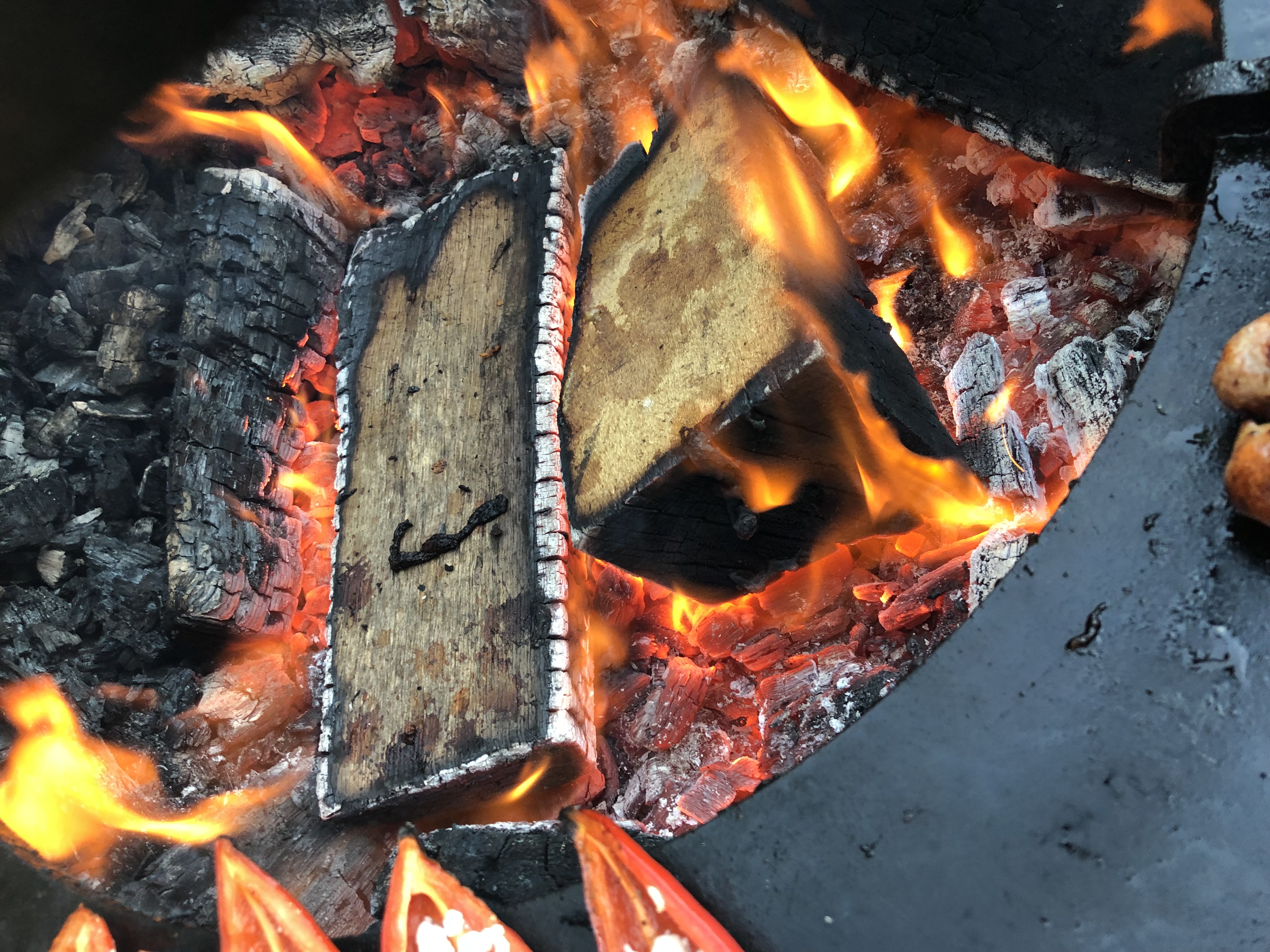 Birkenholz und Glut im Ofyr-Feuer, atmosphärisches Detail vom Live-Cooking