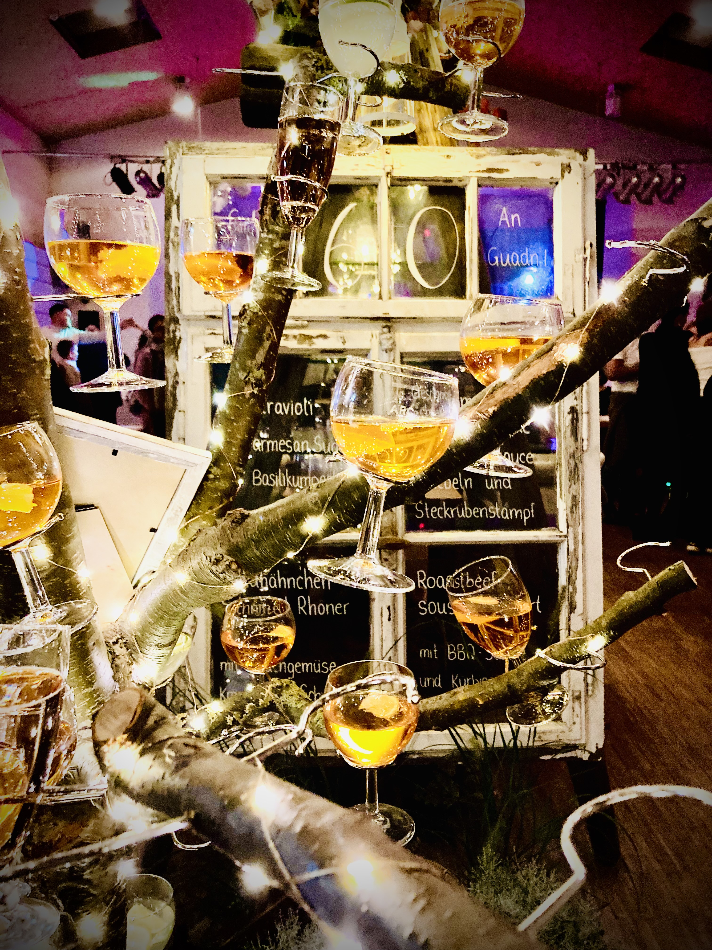 Hängende Sektgläser und Lichterketten — atmosphärische Eventdekoration im Indoor-Setting