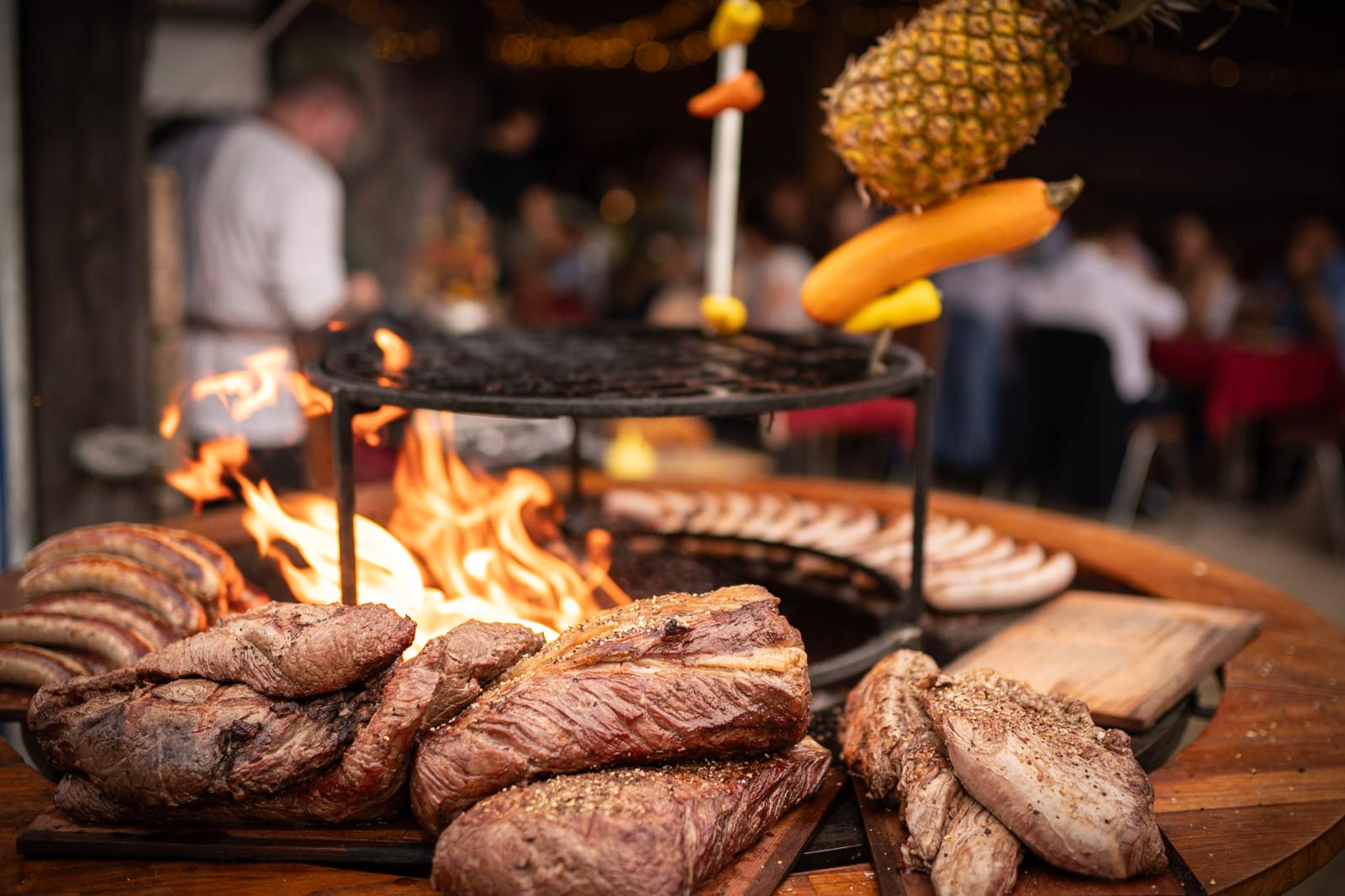Aufgeschnittene Steaks und Würste am Ofyr-Buffet, im Hintergrund die festliche Hochzeitsgesellschaft
